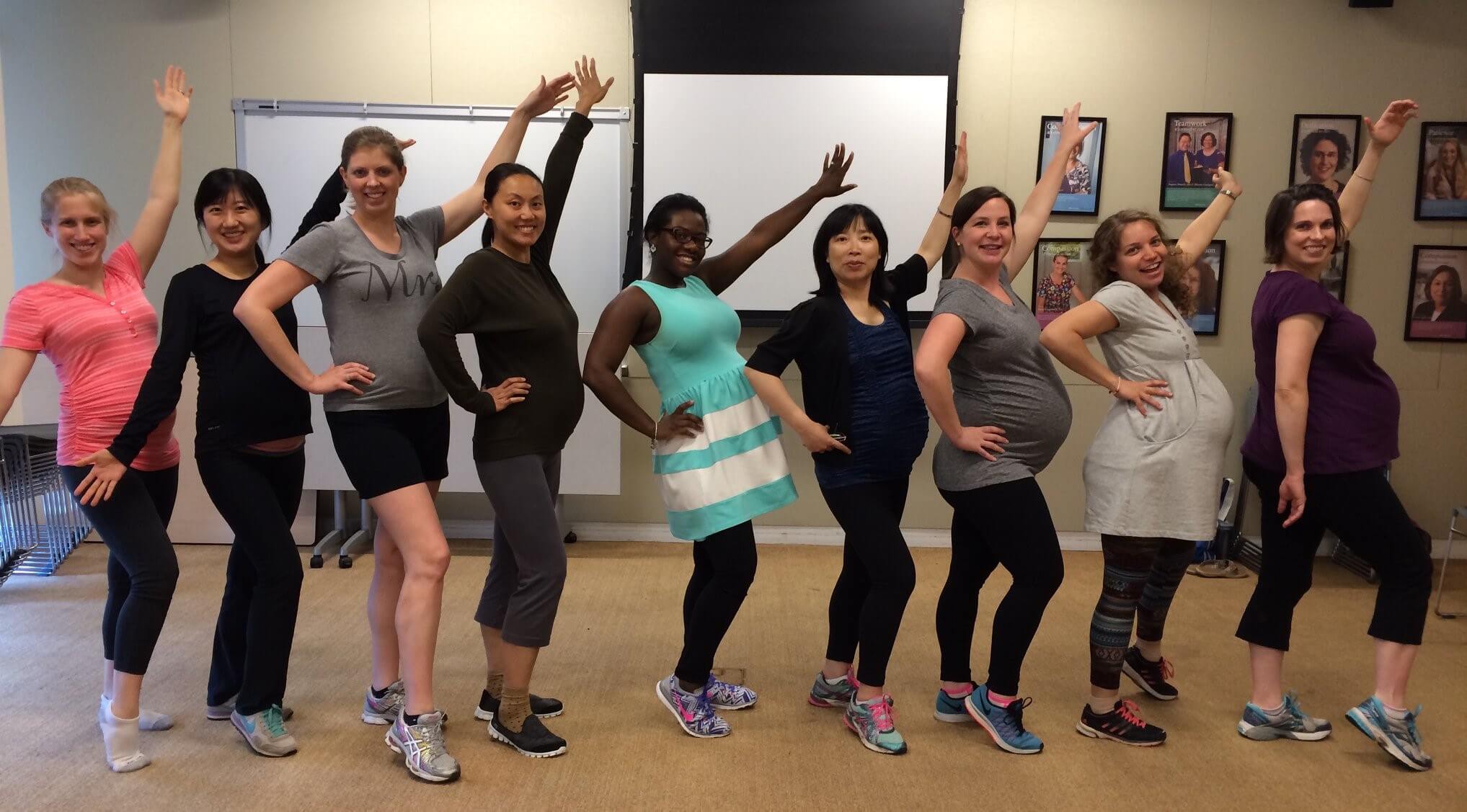A class of pregnant women posing after a dance class.