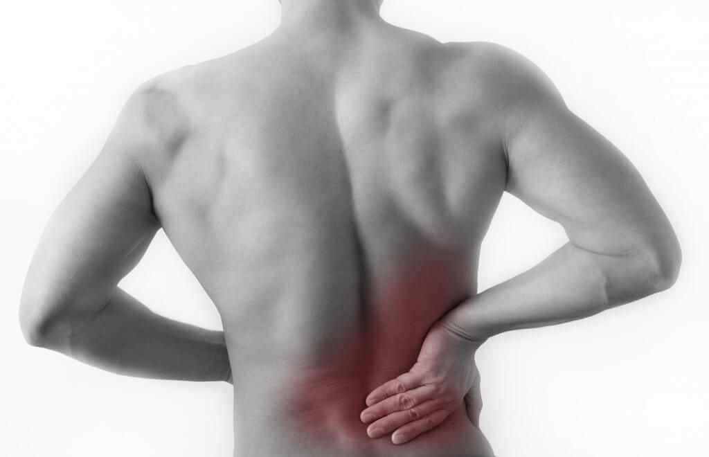 Black and white image of a man holding his back; his lower back is highlighted in red, to imply pain.
