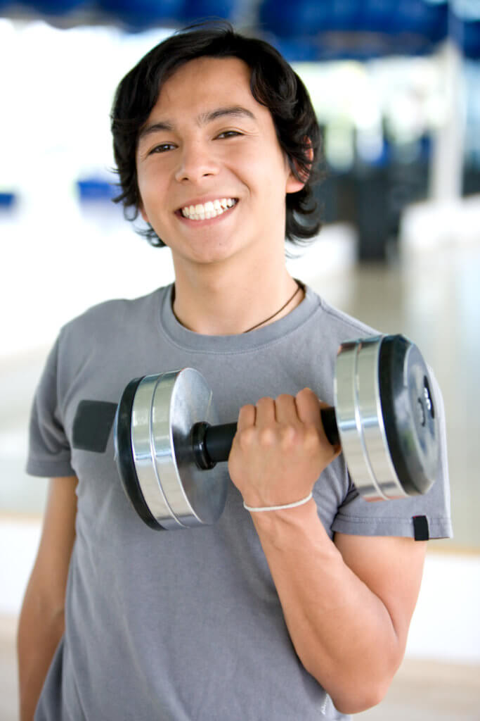 Gentleman in his teens or early 20s, lifting weights at the gym.