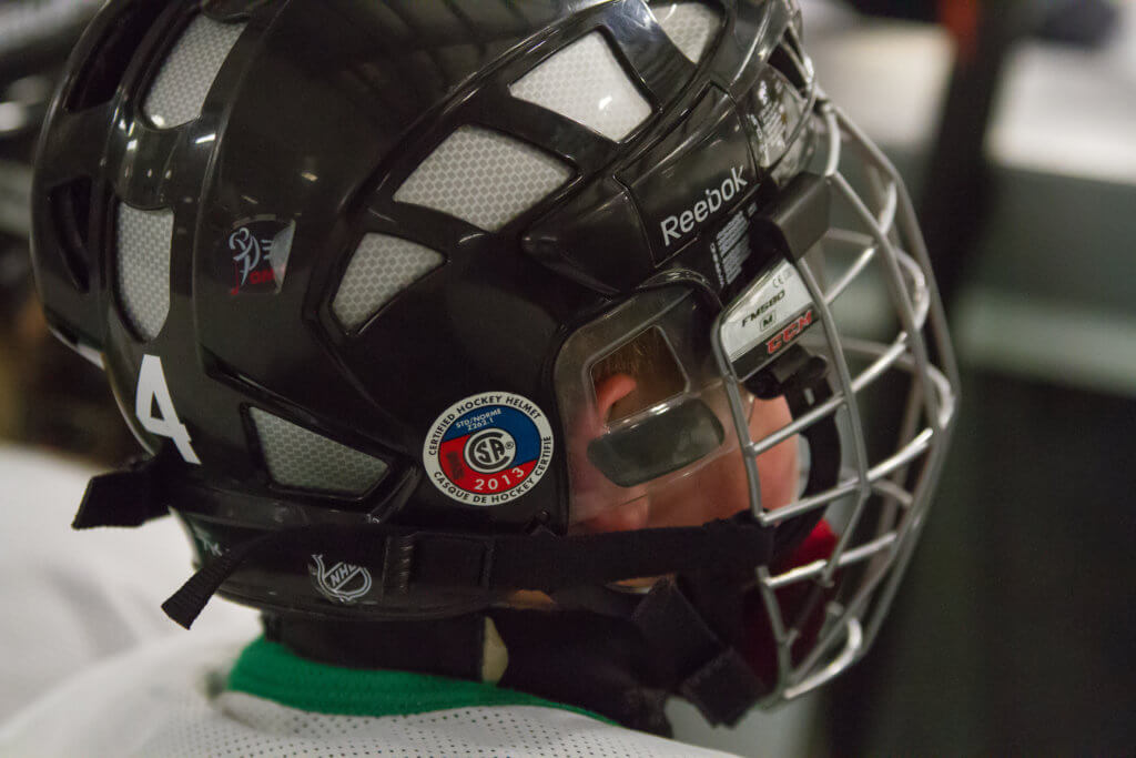 Child wearing a hockey helmet that protects his entire head.
