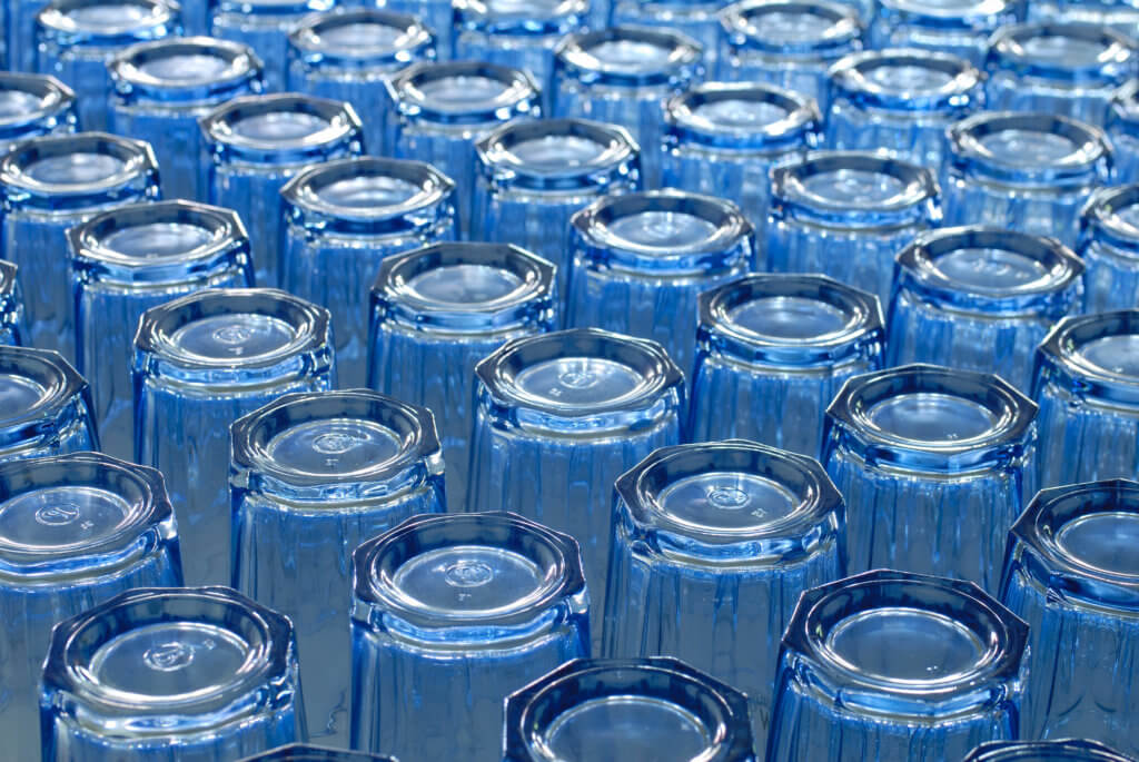 Photograph of empty blue glasses, all upside down, focusing on the bottoms of the glasses.